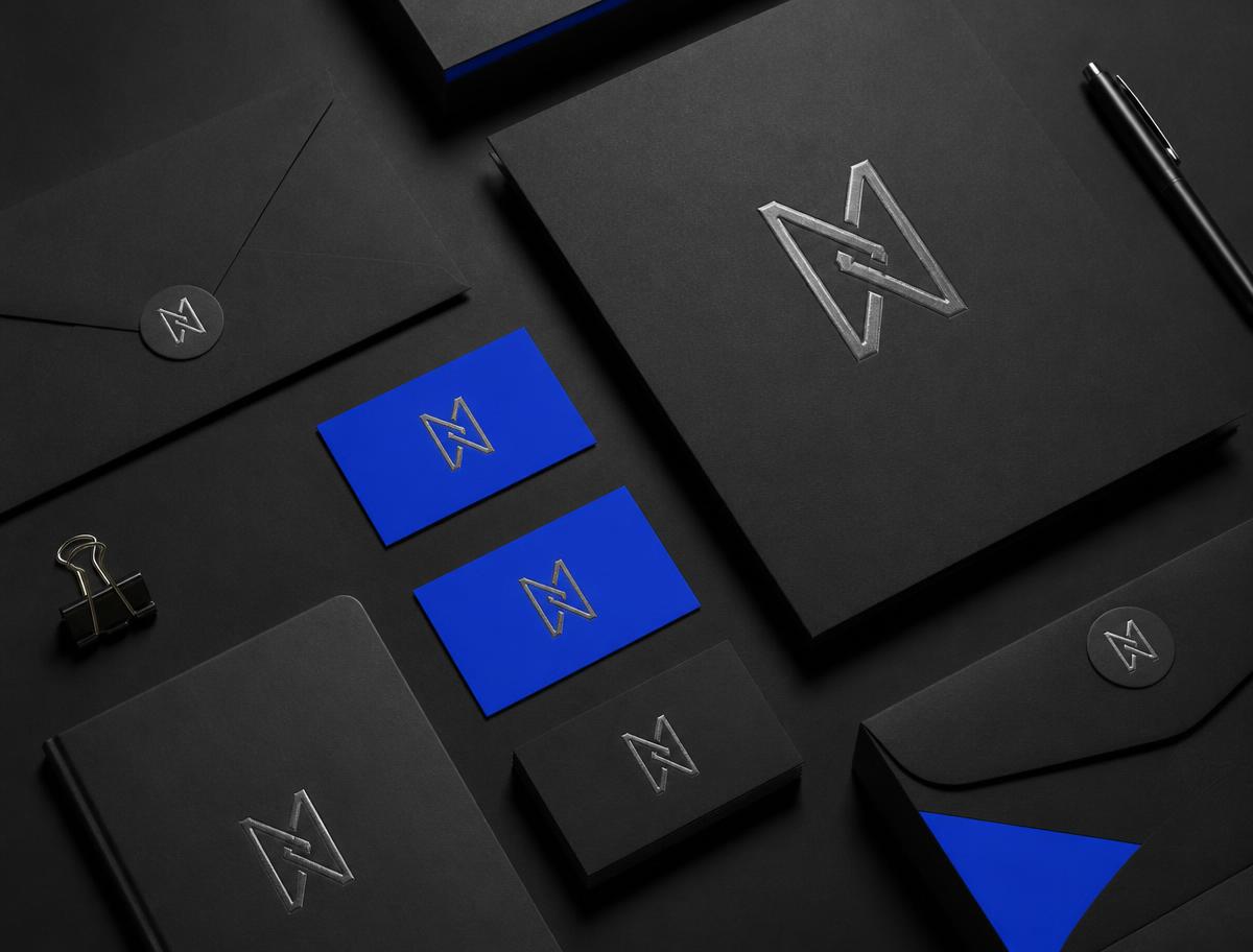 Concept branding flat lay with matte black stationery and an embossed silver monogram